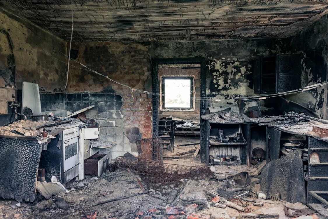 fire damage restoration dayton ohio — technician cleaning soot from walls after house fire